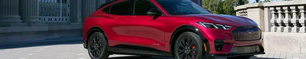 Red electric SUV parked in an urban setting, showcasing sleek design and black wheels.