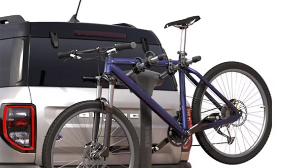 SUV with a rear-mounted bike rack carrying a mountain bike, showcasing outdoor gear setup.