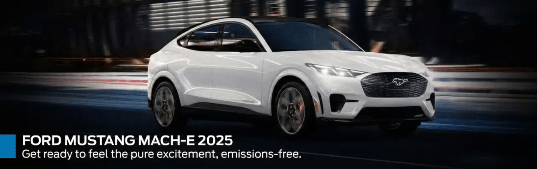 White Ford Mustang Mach-E 2025 driving on city road at night, highlighting its sleek design.