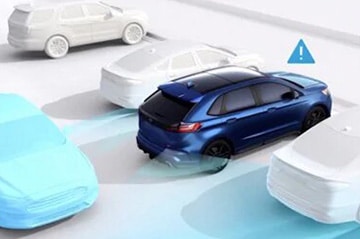 Blue car using parking assistance technology, sensing nearby vehicles with an alert icon.