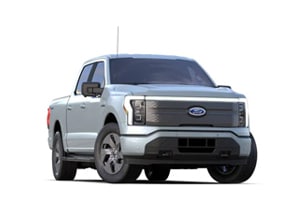 Un pick-up moderne argenté, probablement un modèle Ford, vu de face, avec des feux avant distinctifs.