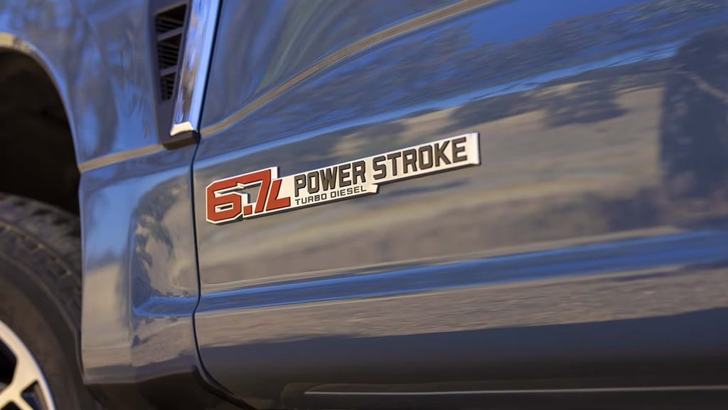 Insigne "6.7L Power Stroke Turbo Diesel" sur la carrosserie d'un véhicule bleu.