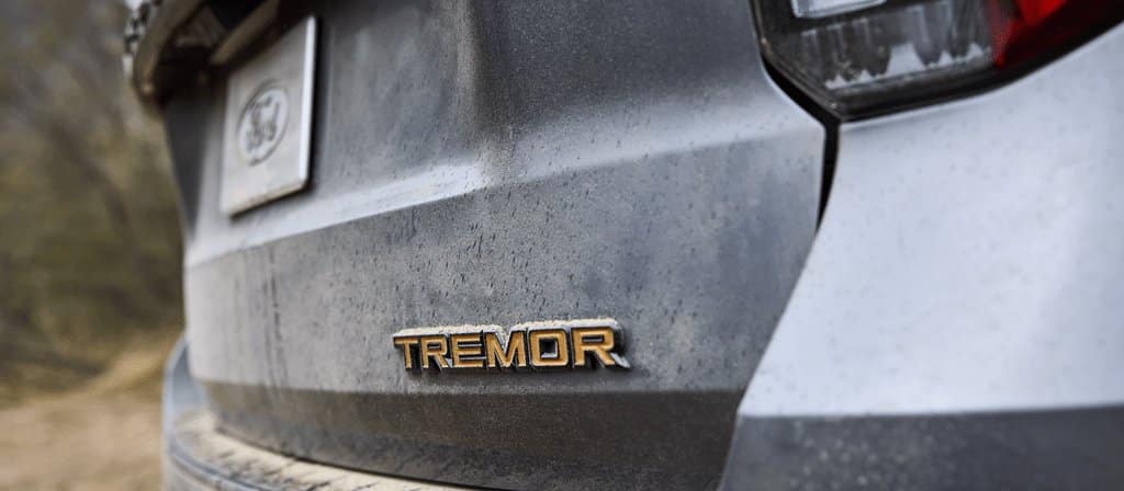 Ford Explorer 2026, vue arrière rapprochée de l'écusson Tremor, carrosserie poussiéreuse