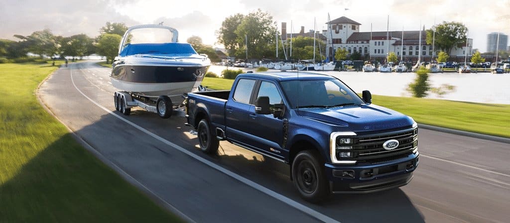 Ford Super Duty F-250 2026, vue latérale avant d'un camion tirant un bateau sur une route