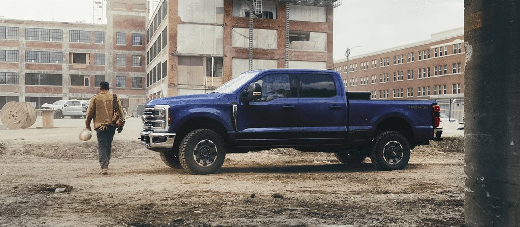 Ford Super Duty F-250 2026, vue latérale d'un pick-up bleu sur un chantier poussiéreux
